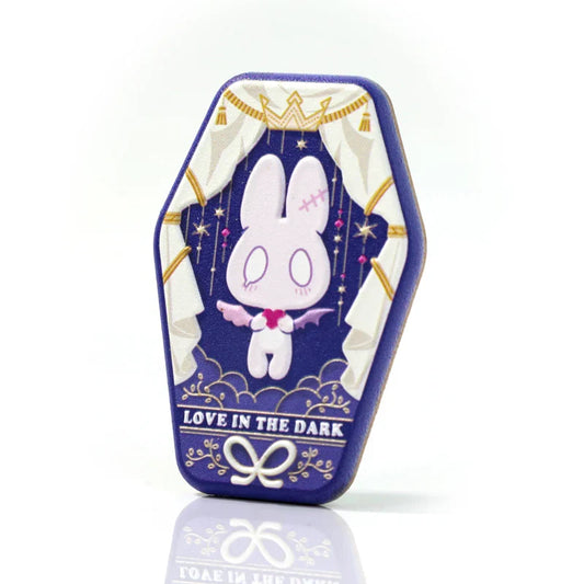 Cute gothic bunny enamel pin with 'Love in the Dark' text, coffin-shaped design, purple and gold accents