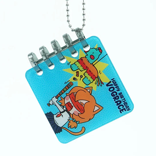 Custom acrylic comic book keychain with cartoon cat hitting piñata, blue background