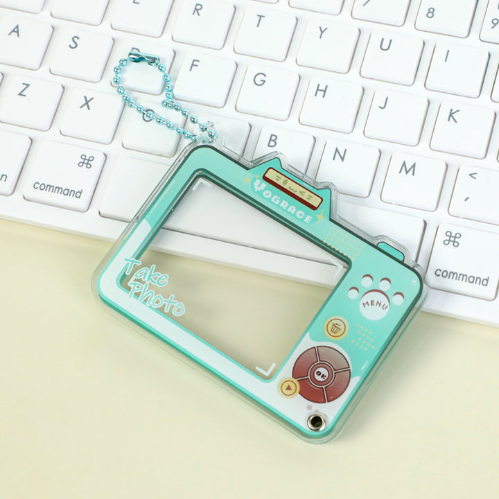 Custom acrylic keychain shaped like a retro camera on a white keyboard