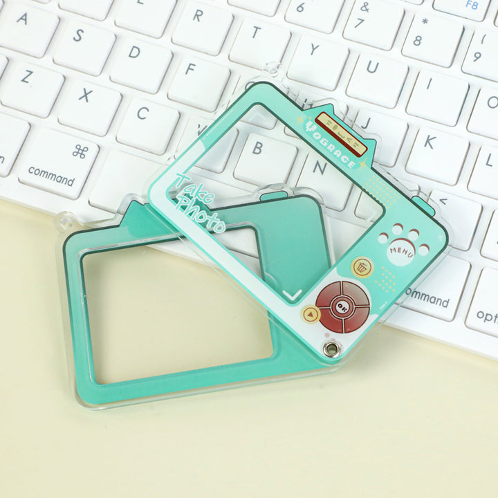 Custom multi-layer acrylic keychain shaped like a camera on a white keyboard
